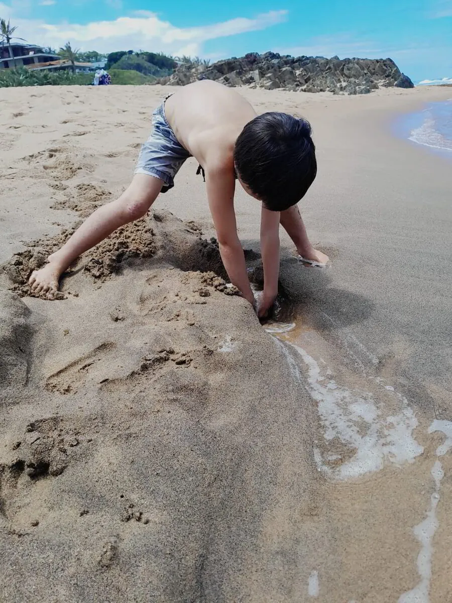 Child digging in the sand at the beach